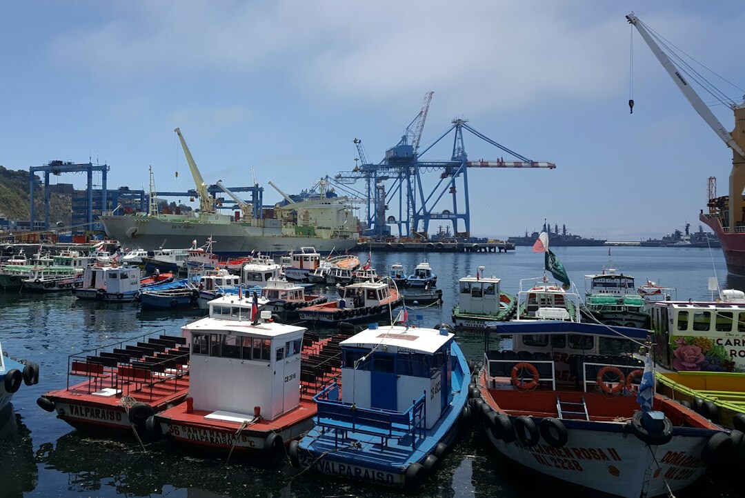 Fisherman mending nets on the colorful docks of Valparaíso