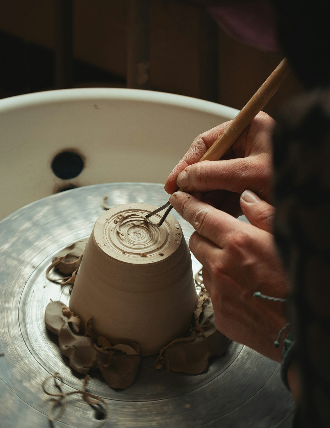 Artisan shaping clay pottery by hand in a small workshop