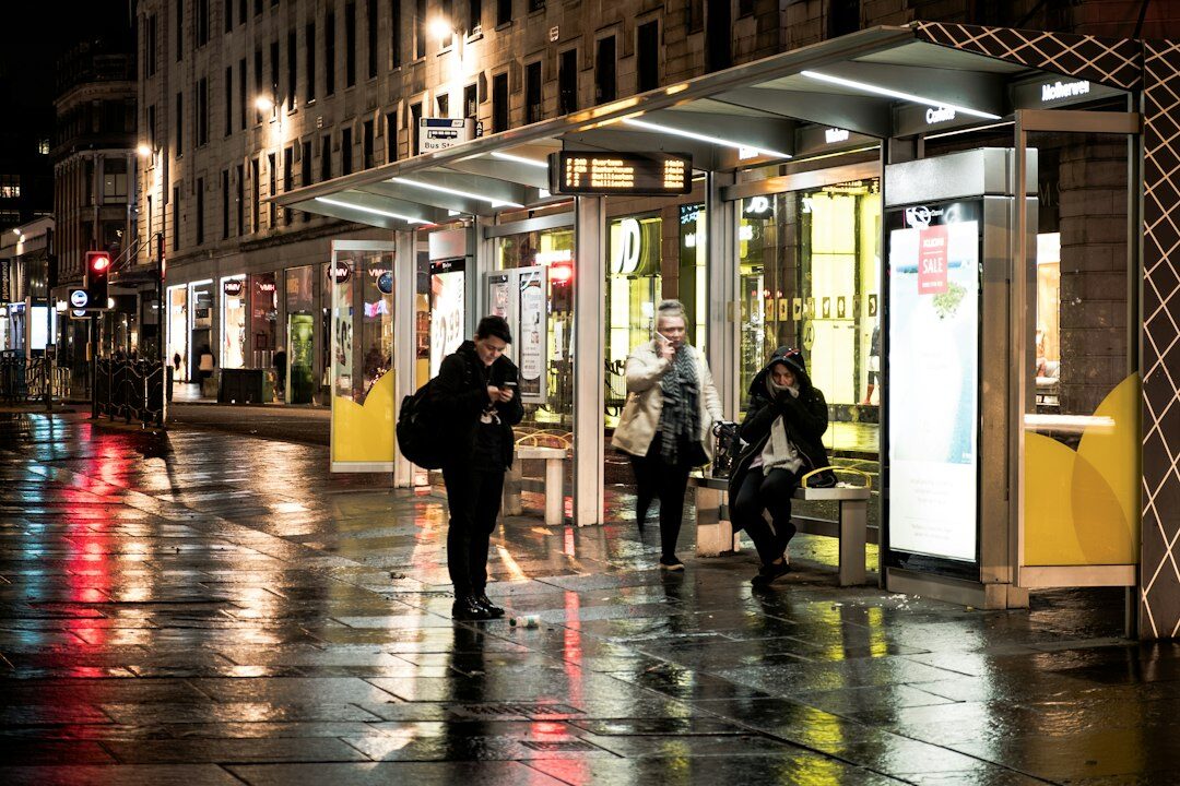 person waiting at bus stop in rain